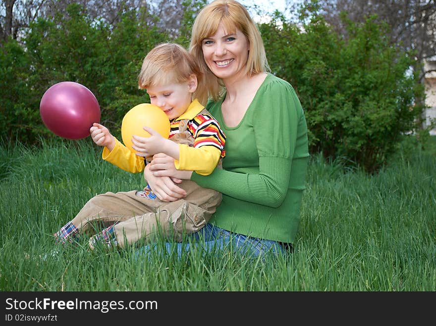 Mum with the son are played with balls in the spring on the nature. Mum with the son are played with balls in the spring on the nature