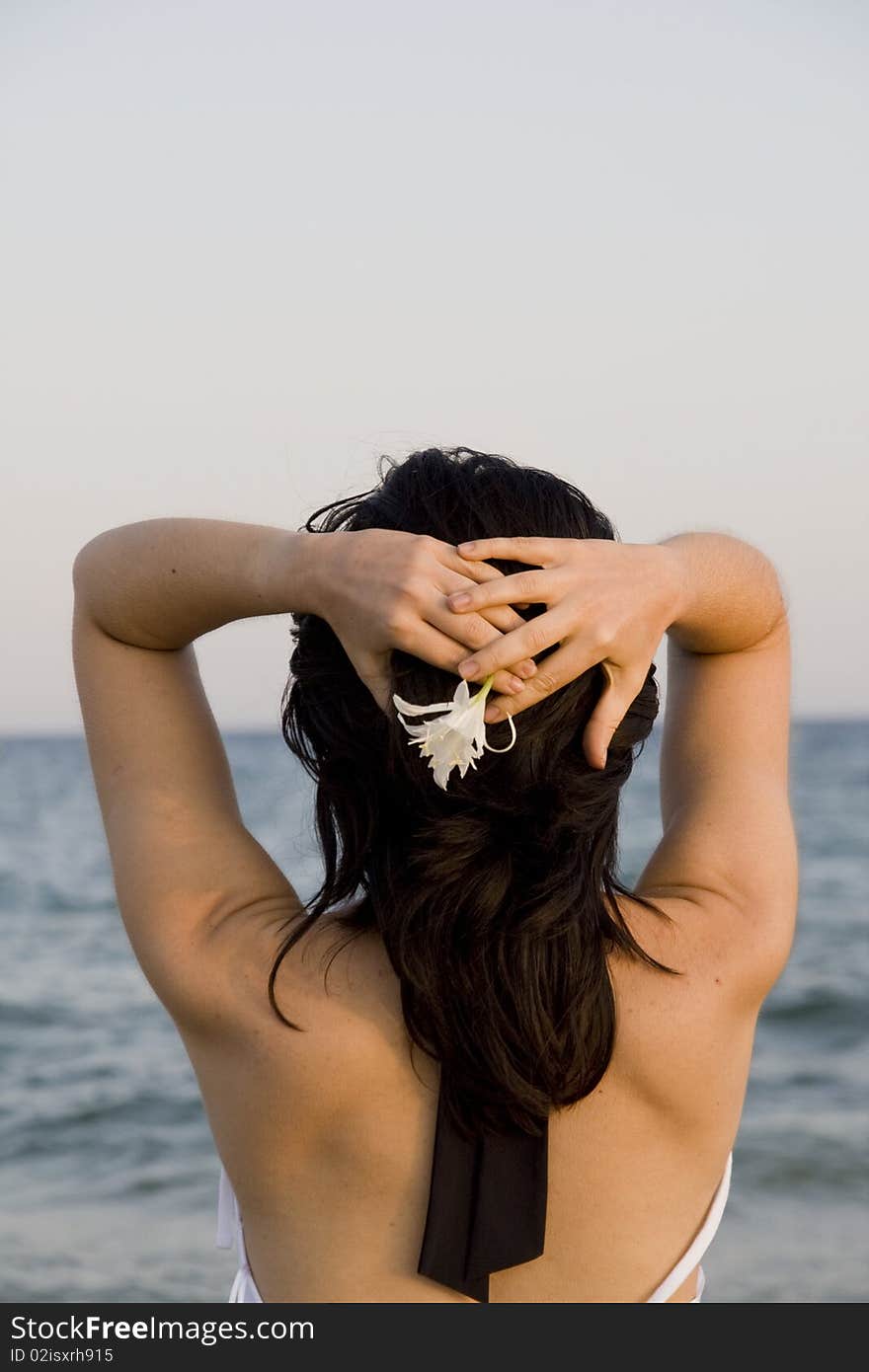 Young woman with flower enjoys the sea. Young woman with flower enjoys the sea.