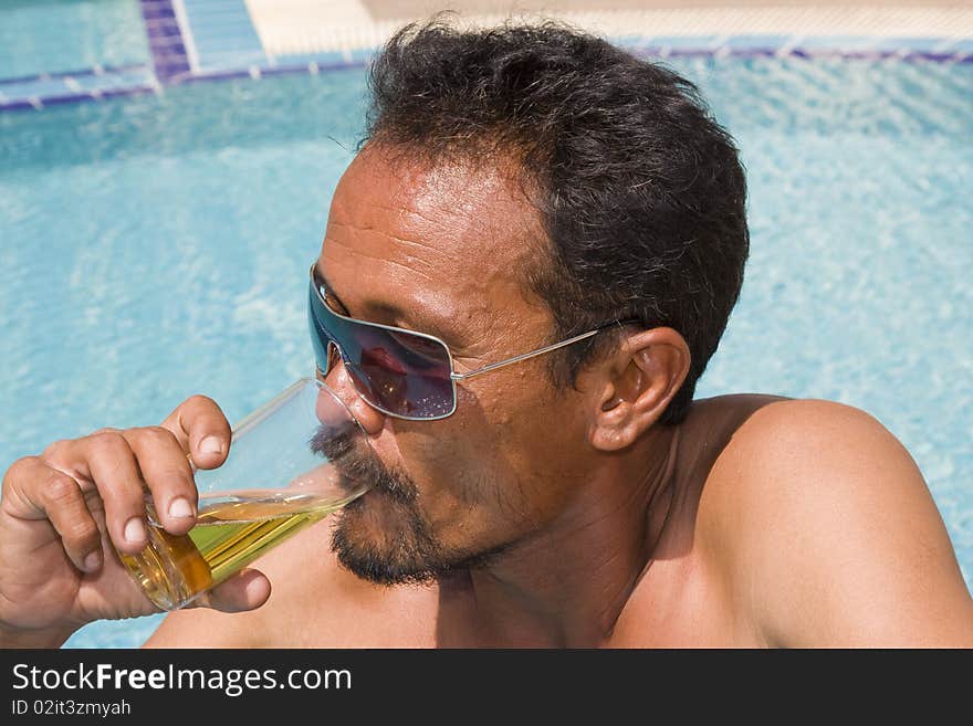 Thai man drinking beer in the pool. Thai man drinking beer in the pool