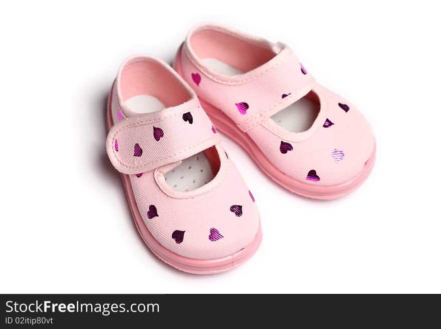 Pair of pink baby shoes with reflective hearts, on white background