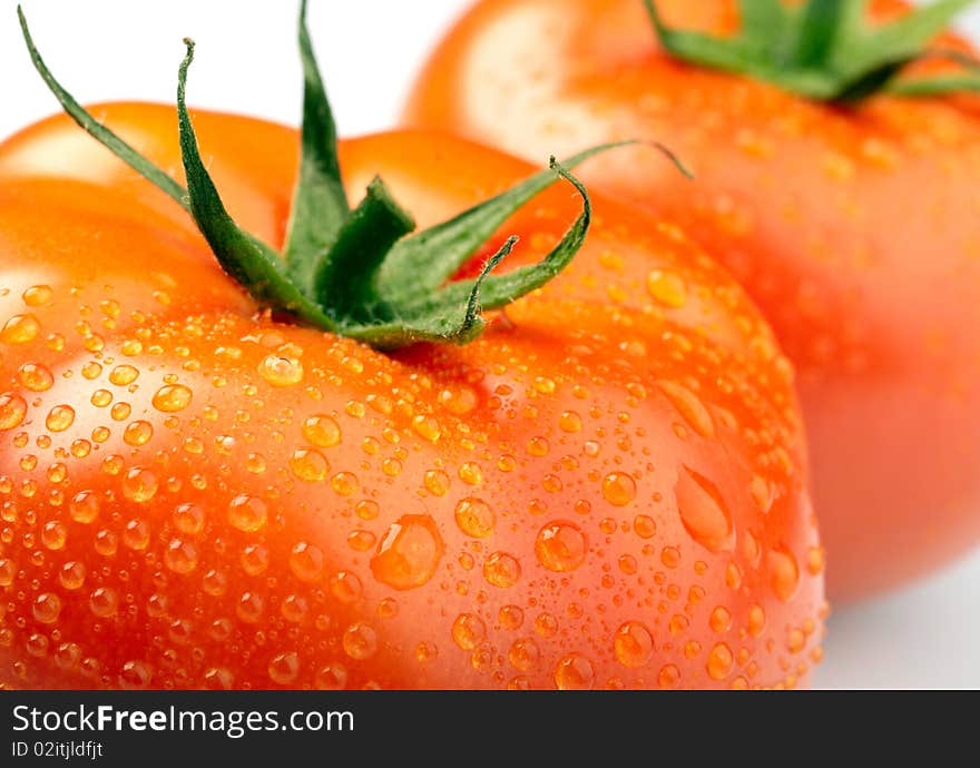 Close-up photo of two tomatoes with water drops