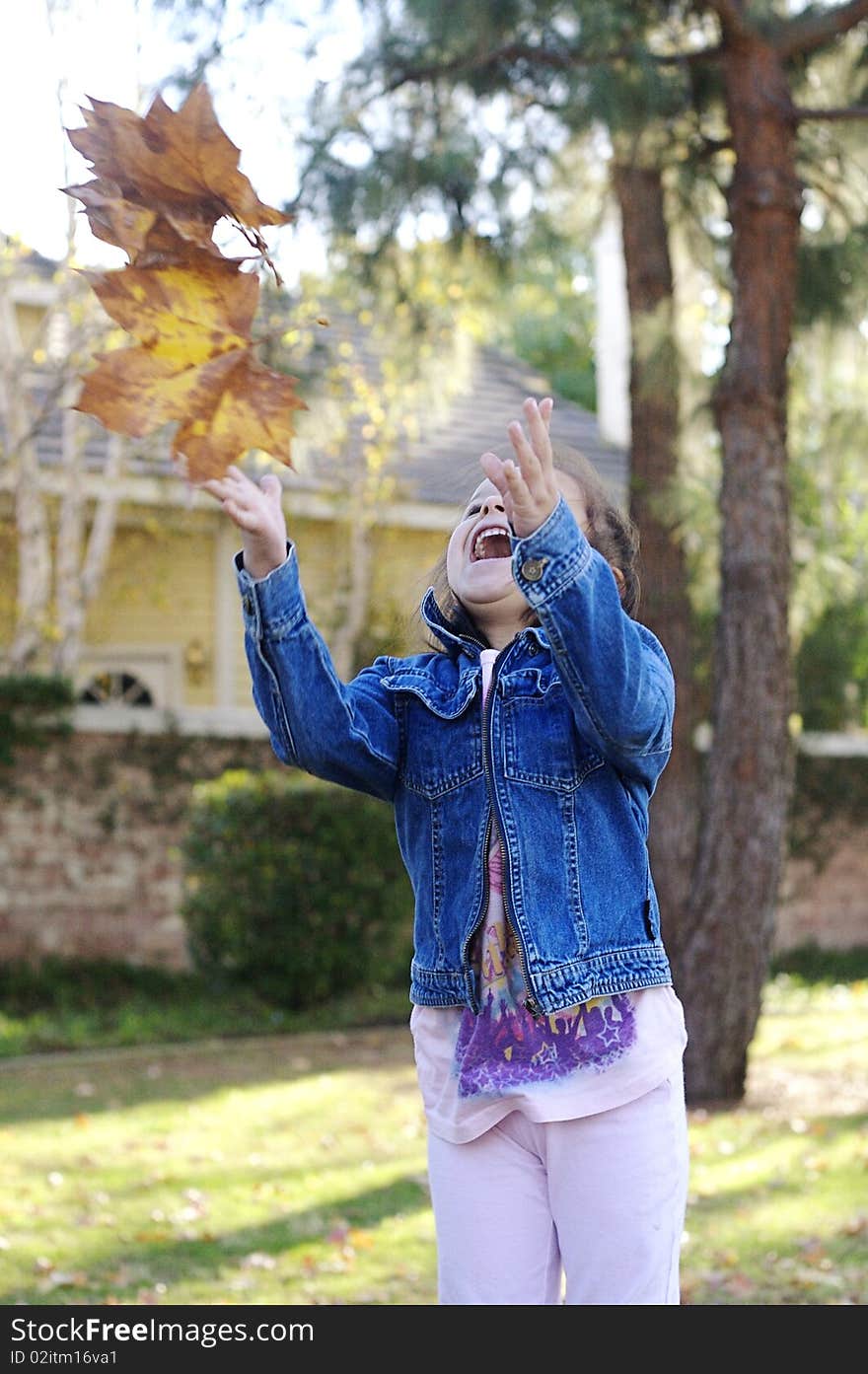 Girl throwing leaves into the air. Girl throwing leaves into the air.