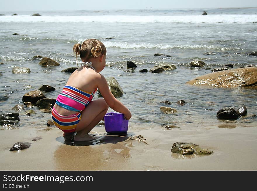 Girl playing in the sand on the beach