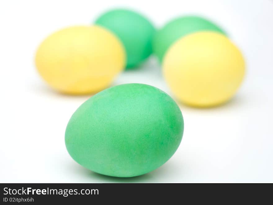 Yellow and green Easter eggs isolated on white