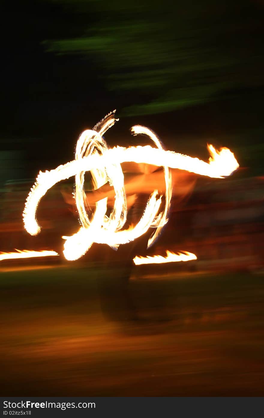 Fire dancer at night, in front of blured background. Fire dancer at night, in front of blured background.