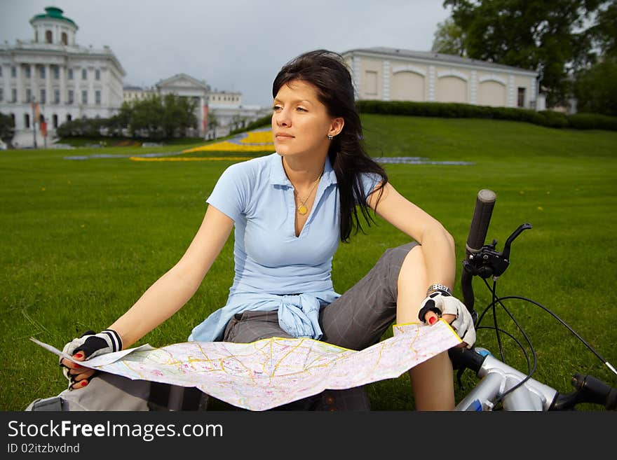 Young caucasian female biker with the city map