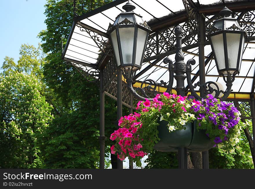 Ancient lantern decorated with flowers on the background of the roof overhang. Ancient lantern decorated with flowers on the background of the roof overhang