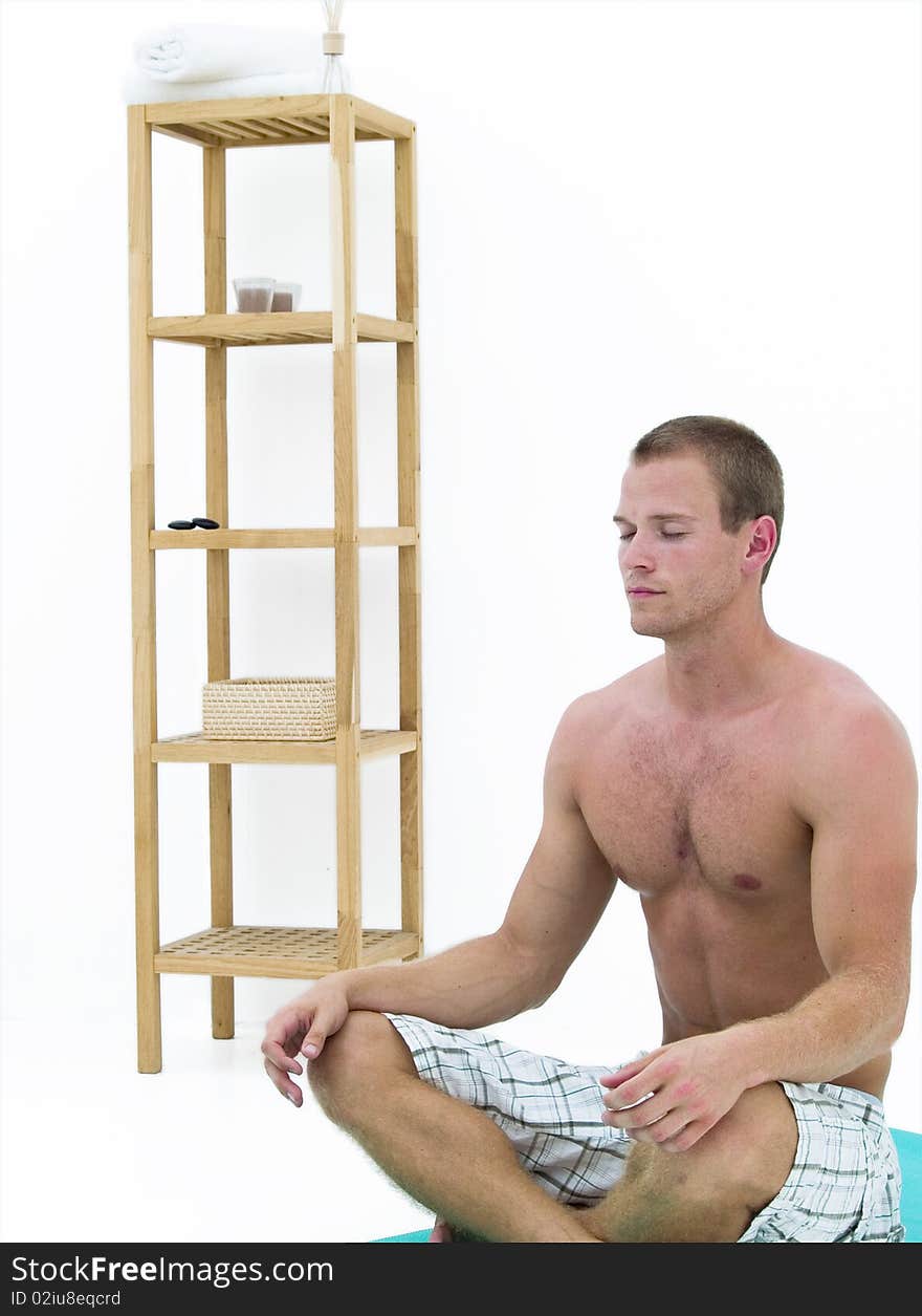 Handsome man relaxing and sitting on a green mat meditating. Handsome man relaxing and sitting on a green mat meditating