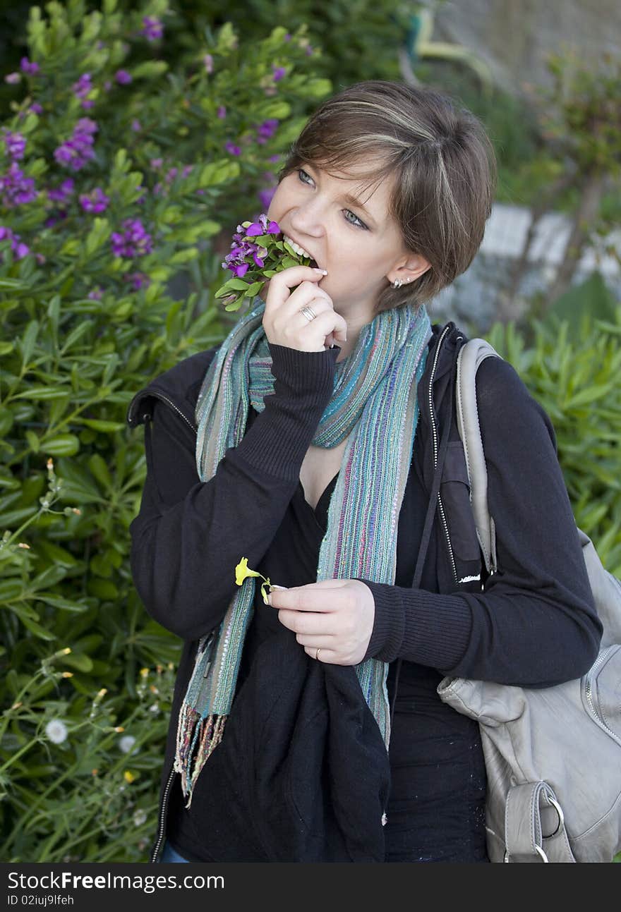 A girl pretending to eat a bunch of flowers. A girl pretending to eat a bunch of flowers