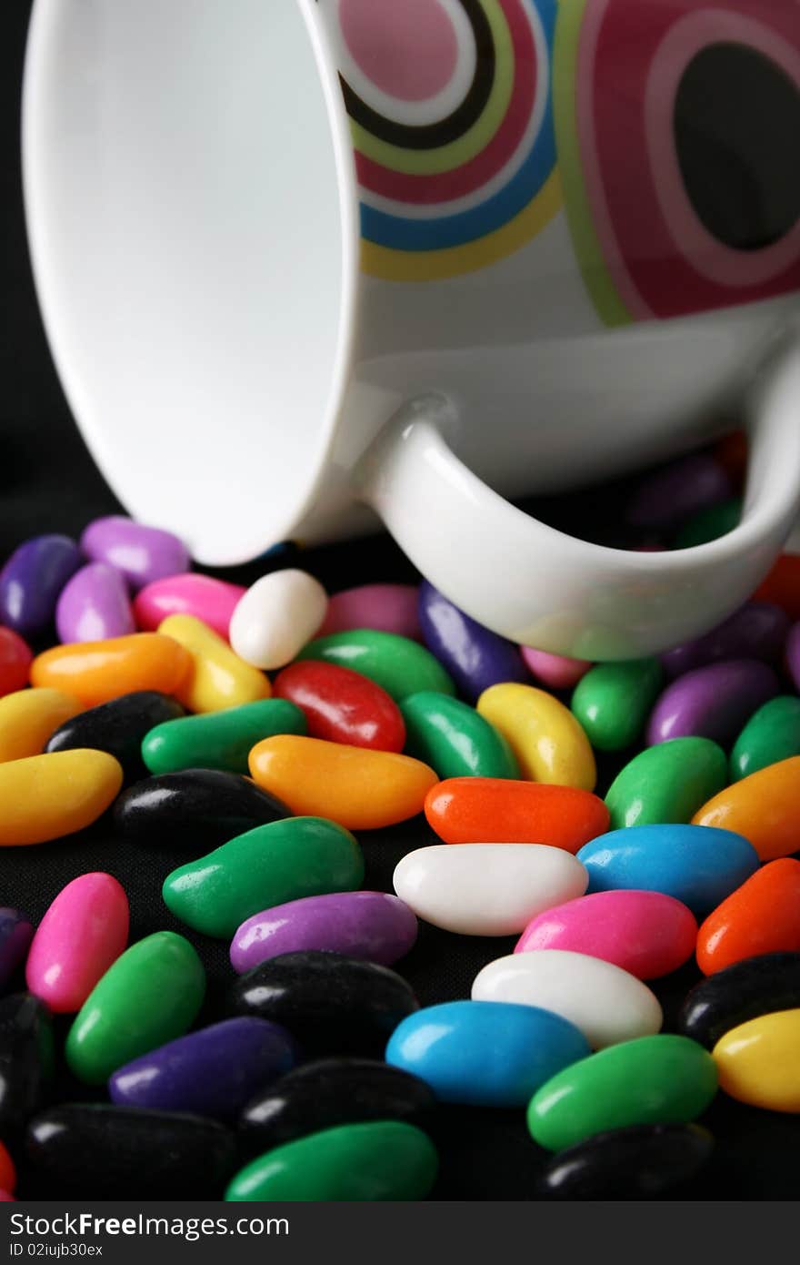 Colorful coffee mug amongst lots of jelly beans. Colorful coffee mug amongst lots of jelly beans