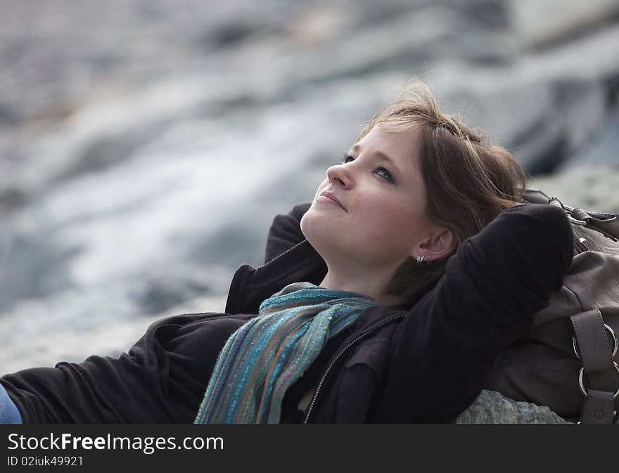 A young girl relaxing on the beach in spring. A young girl relaxing on the beach in spring