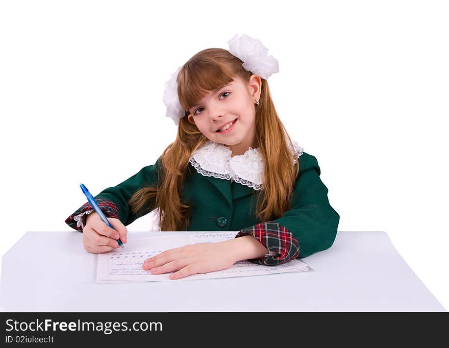 Portrait of a sweet little girl at her classroom, writing an exam. A happy schoolgirl doing her homework. Young student writing.