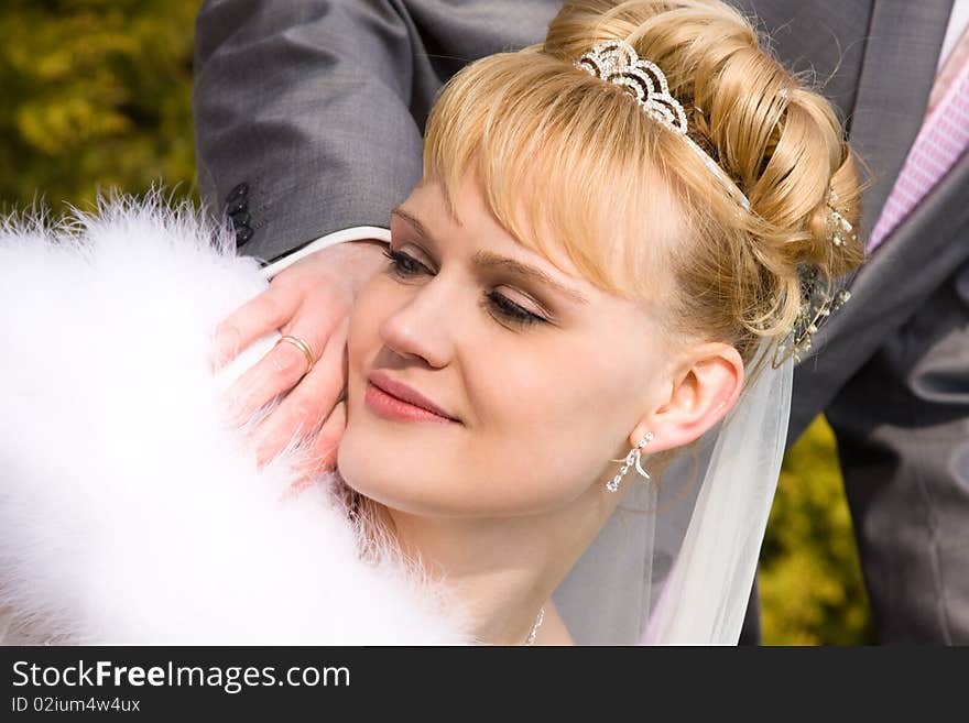 Beautiful bride is looking at the bride's wedding ring. Newlywed outside. Beautiful bride is looking at the bride's wedding ring. Newlywed outside.