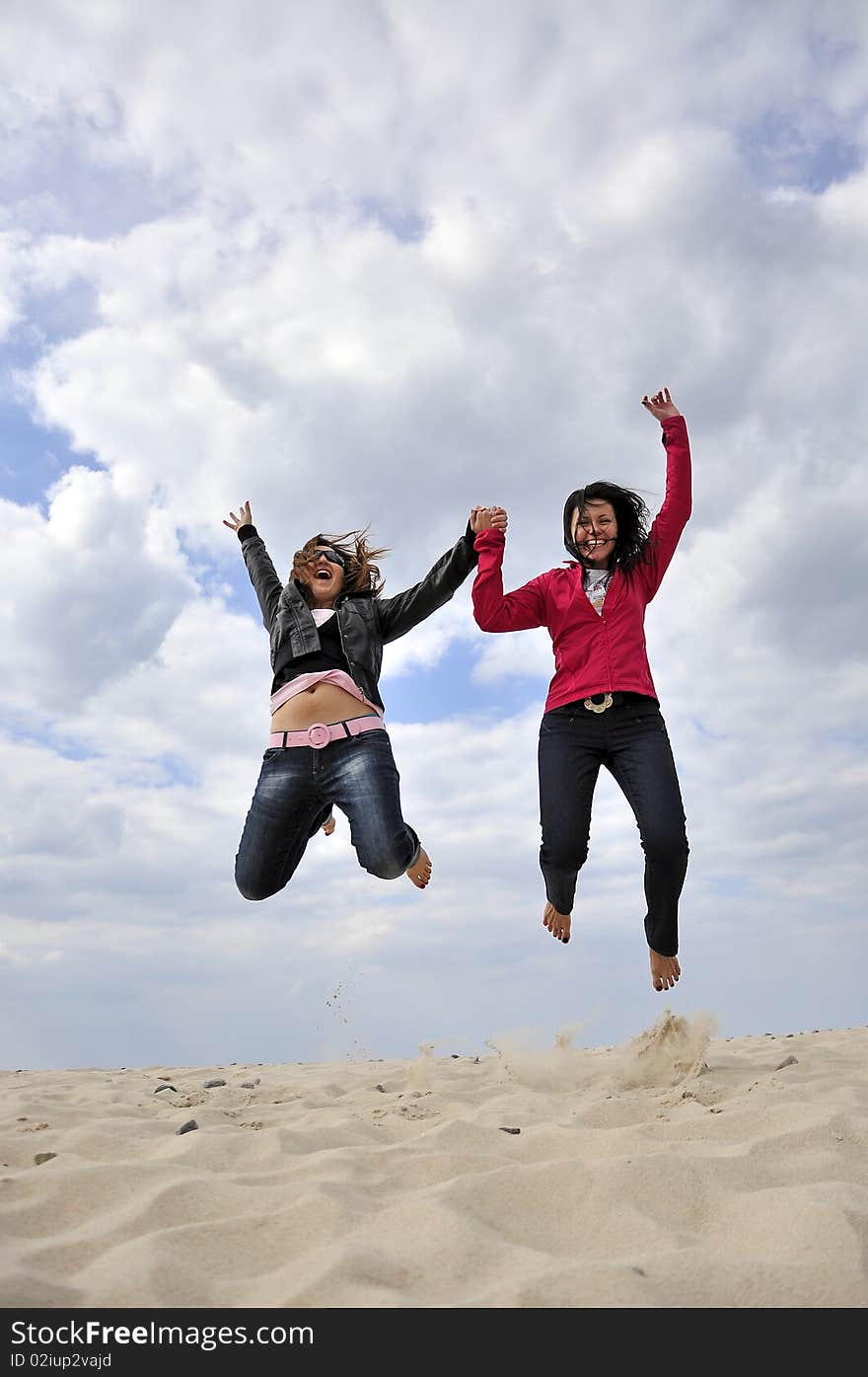 An image showing young girls jumping on the beach. An image showing young girls jumping on the beach