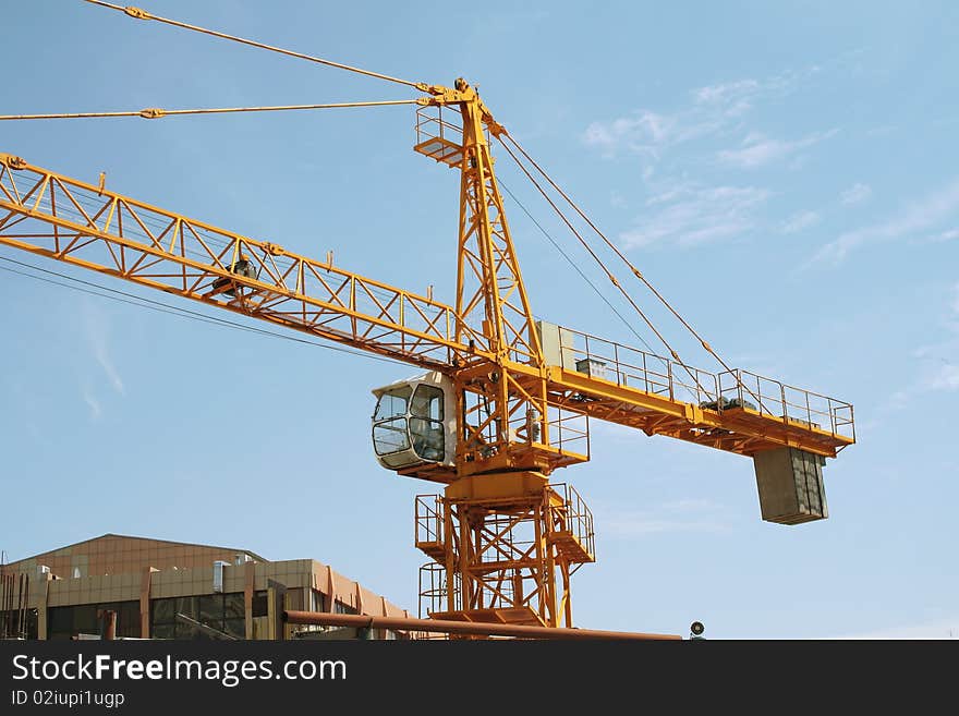 Crane. Against the background of blue sky.