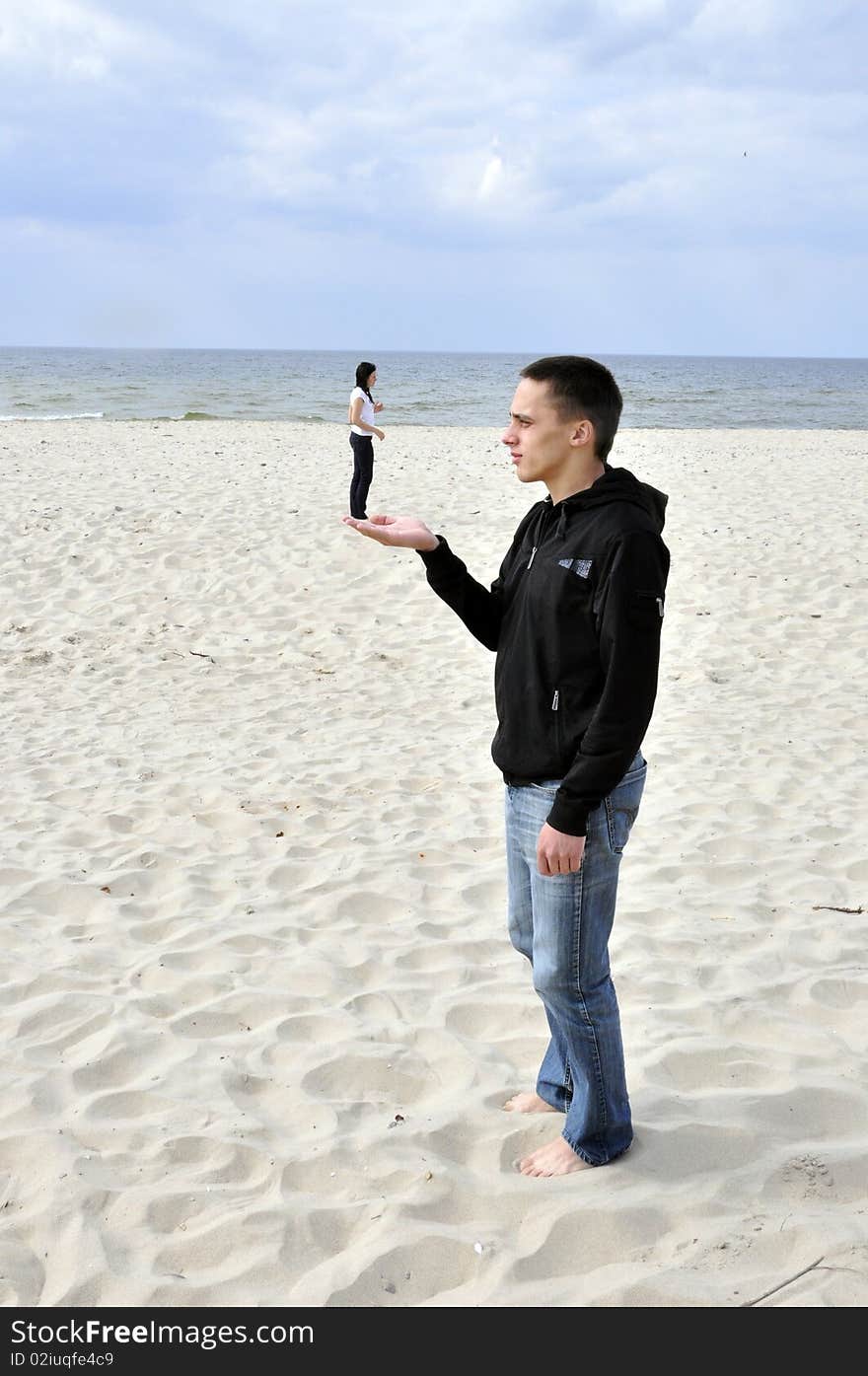 An image showing young boy holding girl on his hand on the beach. An image showing young boy holding girl on his hand on the beach