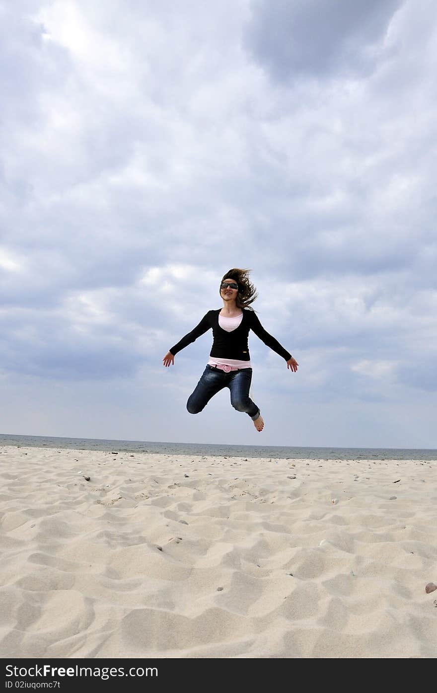 An image showing young girl jumping on the beach. An image showing young girl jumping on the beach