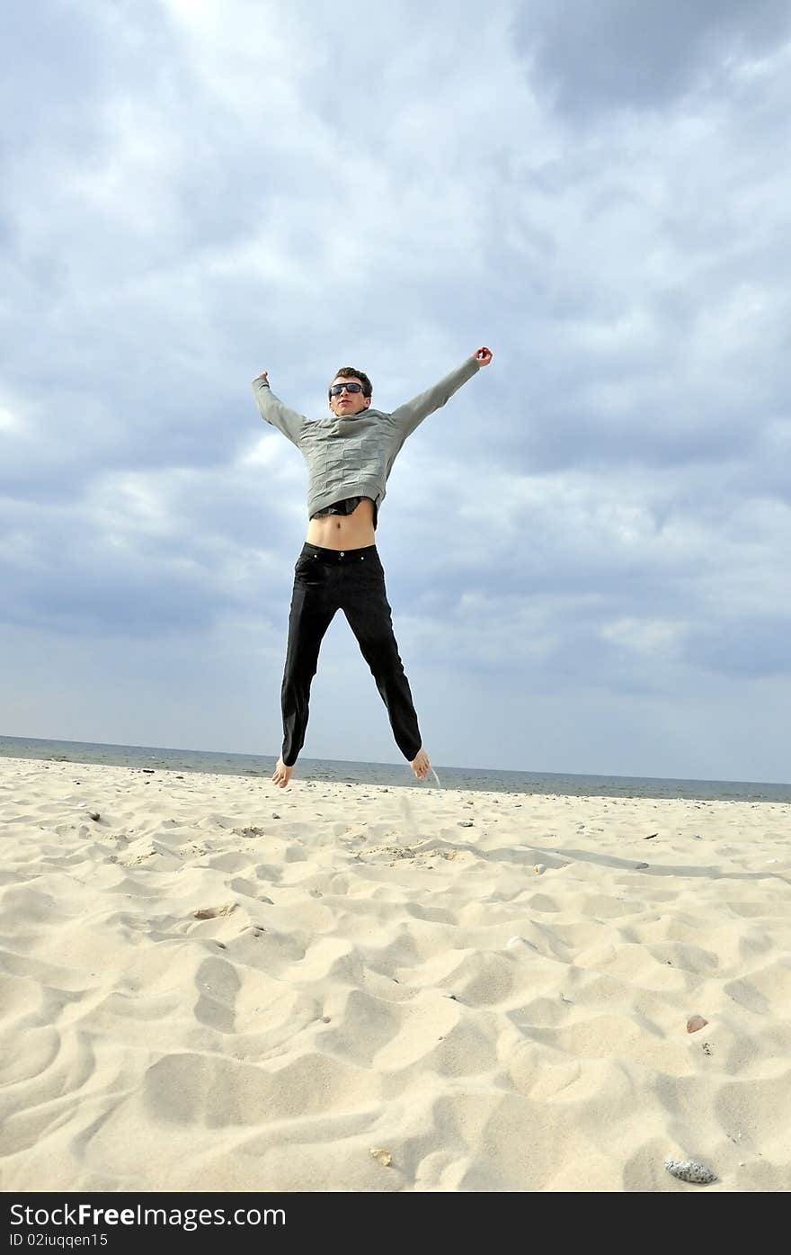 An image showing young boy jumping on the beach. An image showing young boy jumping on the beach