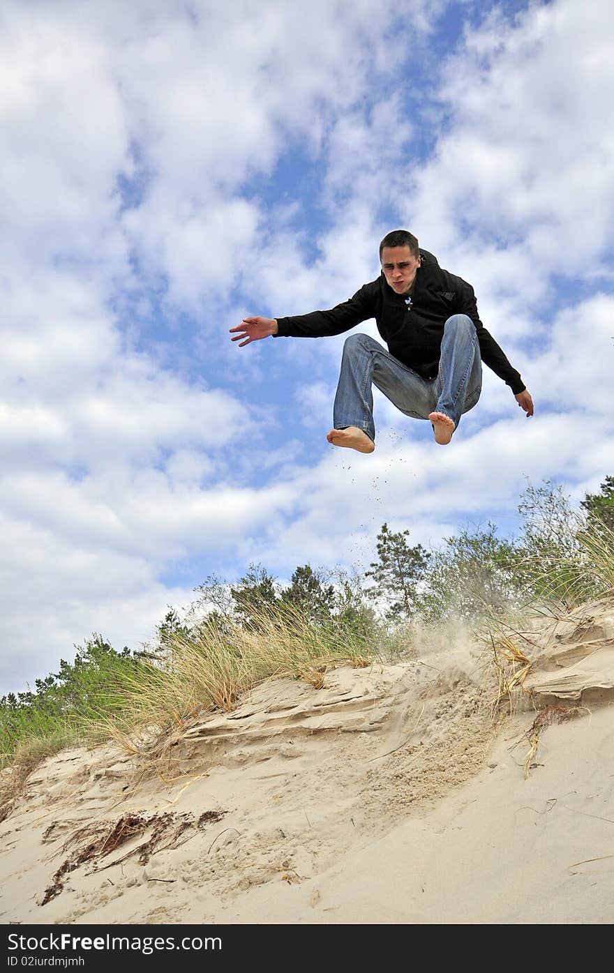 An image showing young boy jumping on the beach. An image showing young boy jumping on the beach