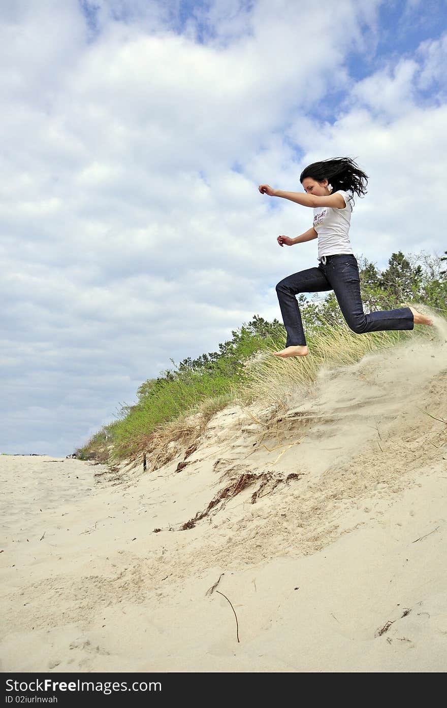 An image showing young girl jumping on the beach. An image showing young girl jumping on the beach