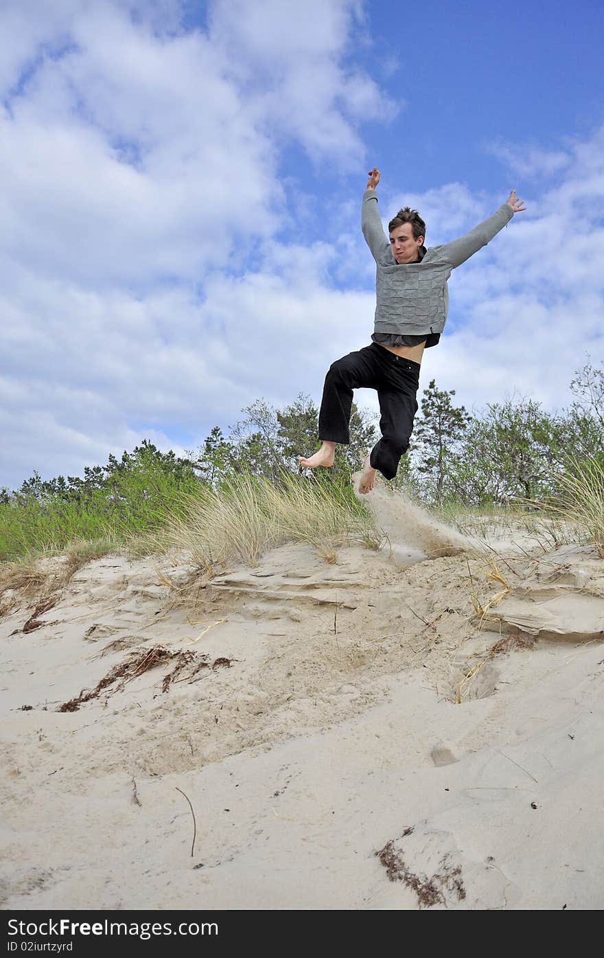 An image showing young boy jumping on the beach. An image showing young boy jumping on the beach