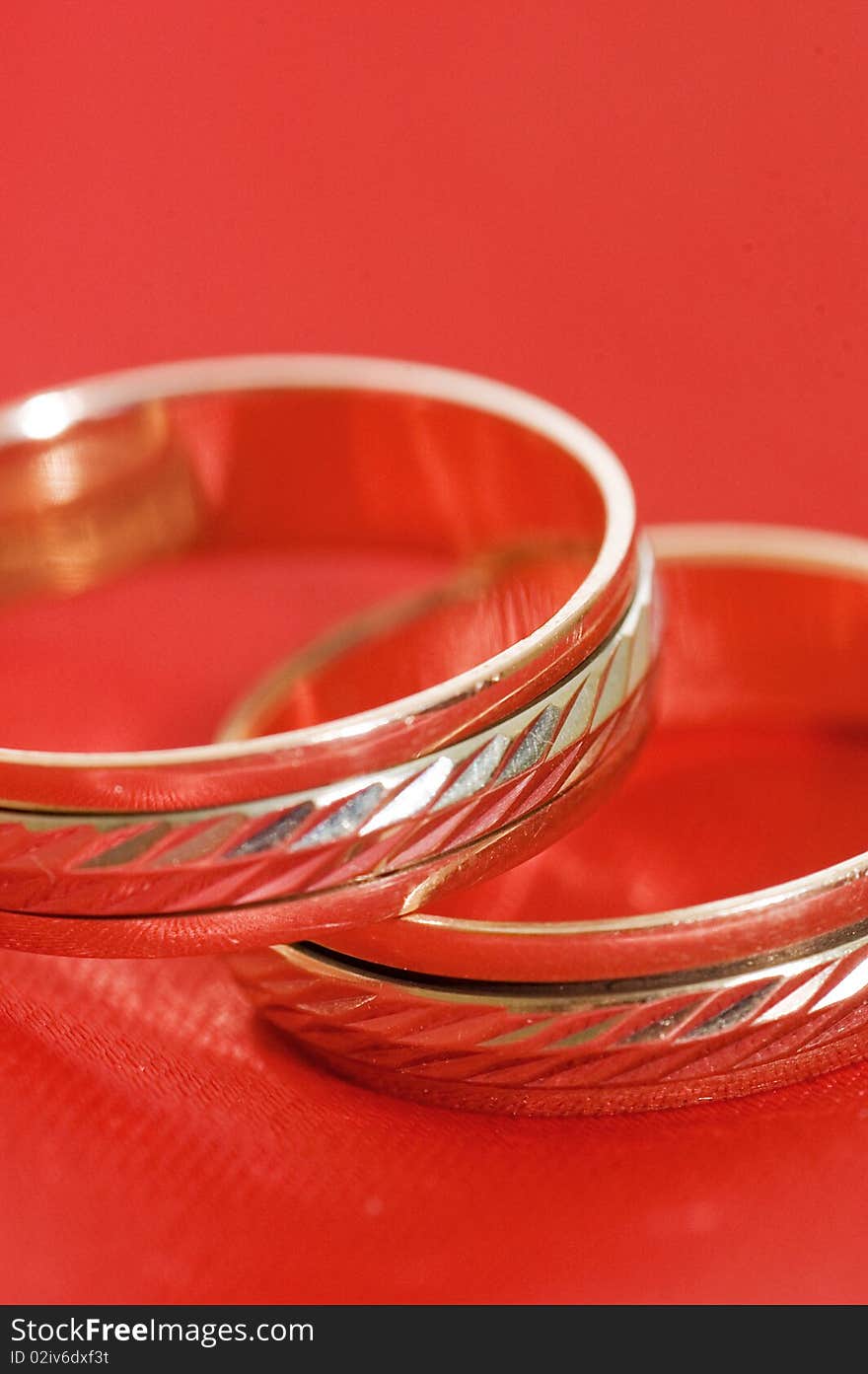 Two gold wedding rings on the red close up