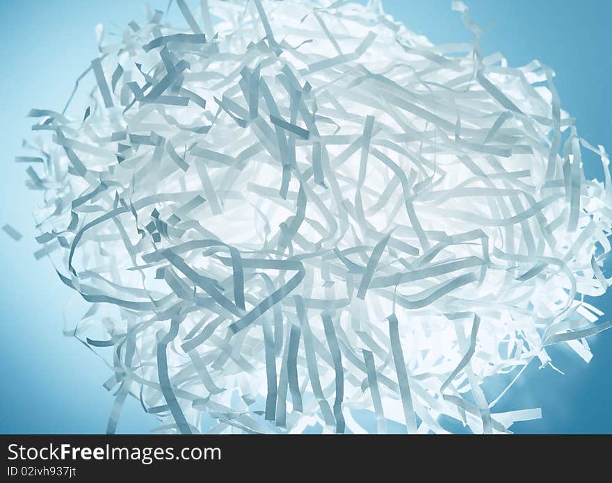 Sliced paper waste on a blue background