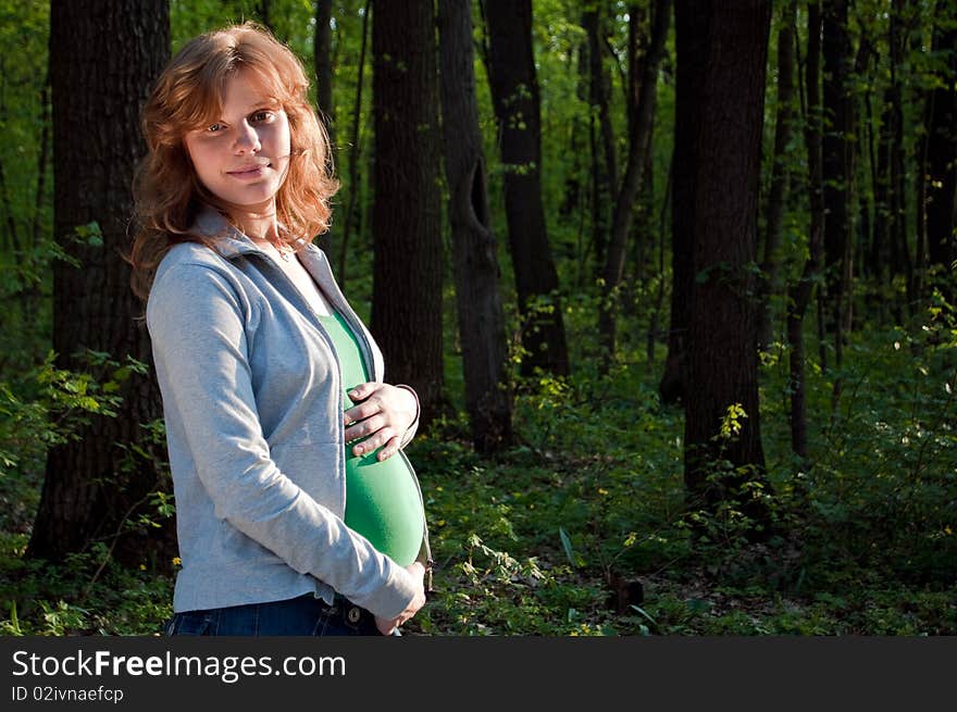 Happy young pregnant woman holding