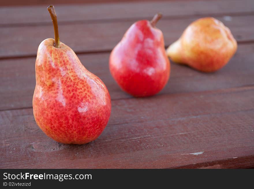 The three pears on the wooden background. The three pears on the wooden background