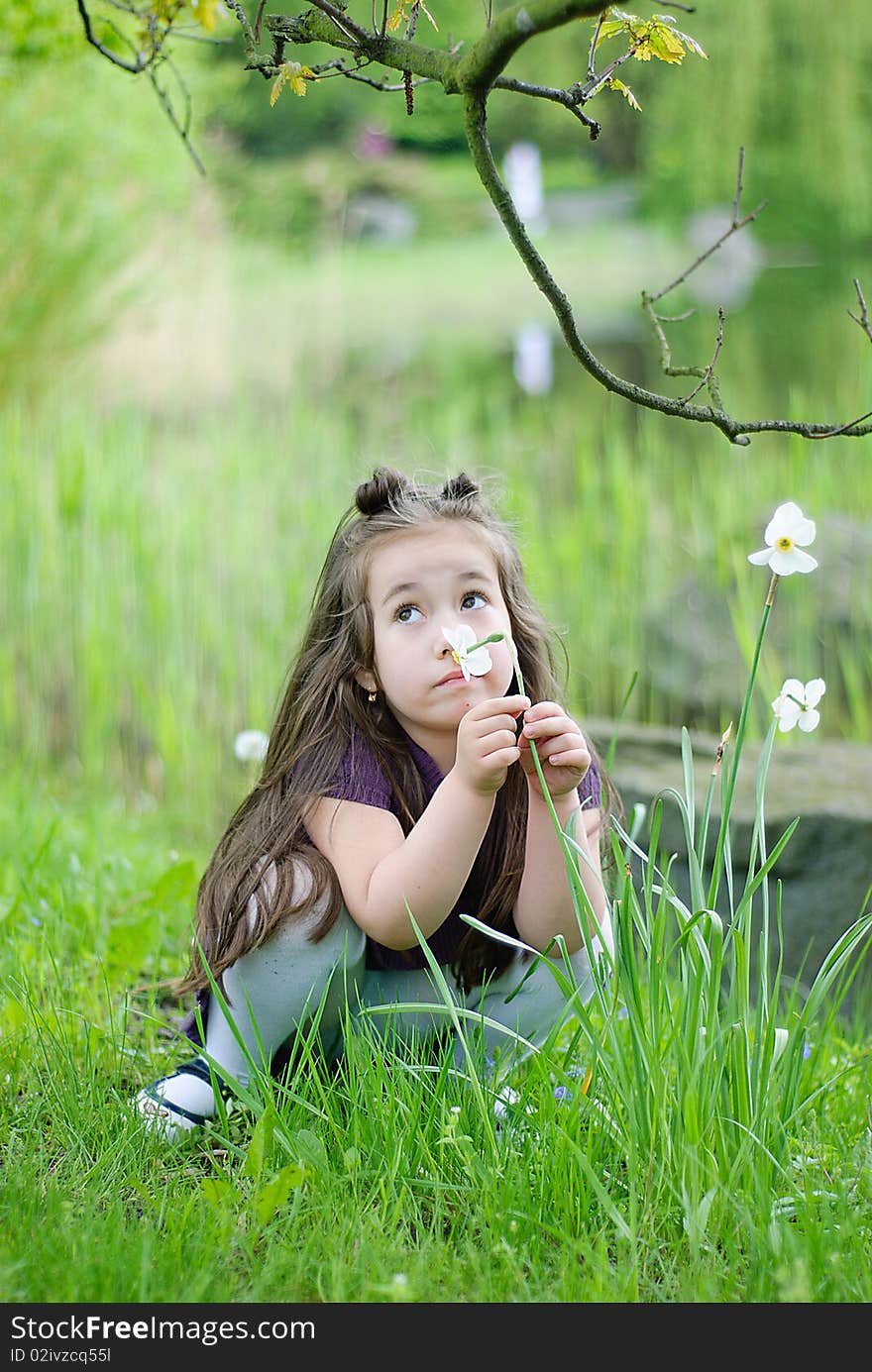 Thoughtful girl on the grass in park