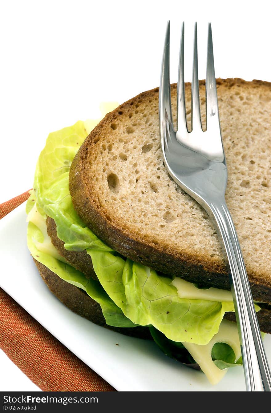 Dark bread sandwich with standing fork, isolated on white background