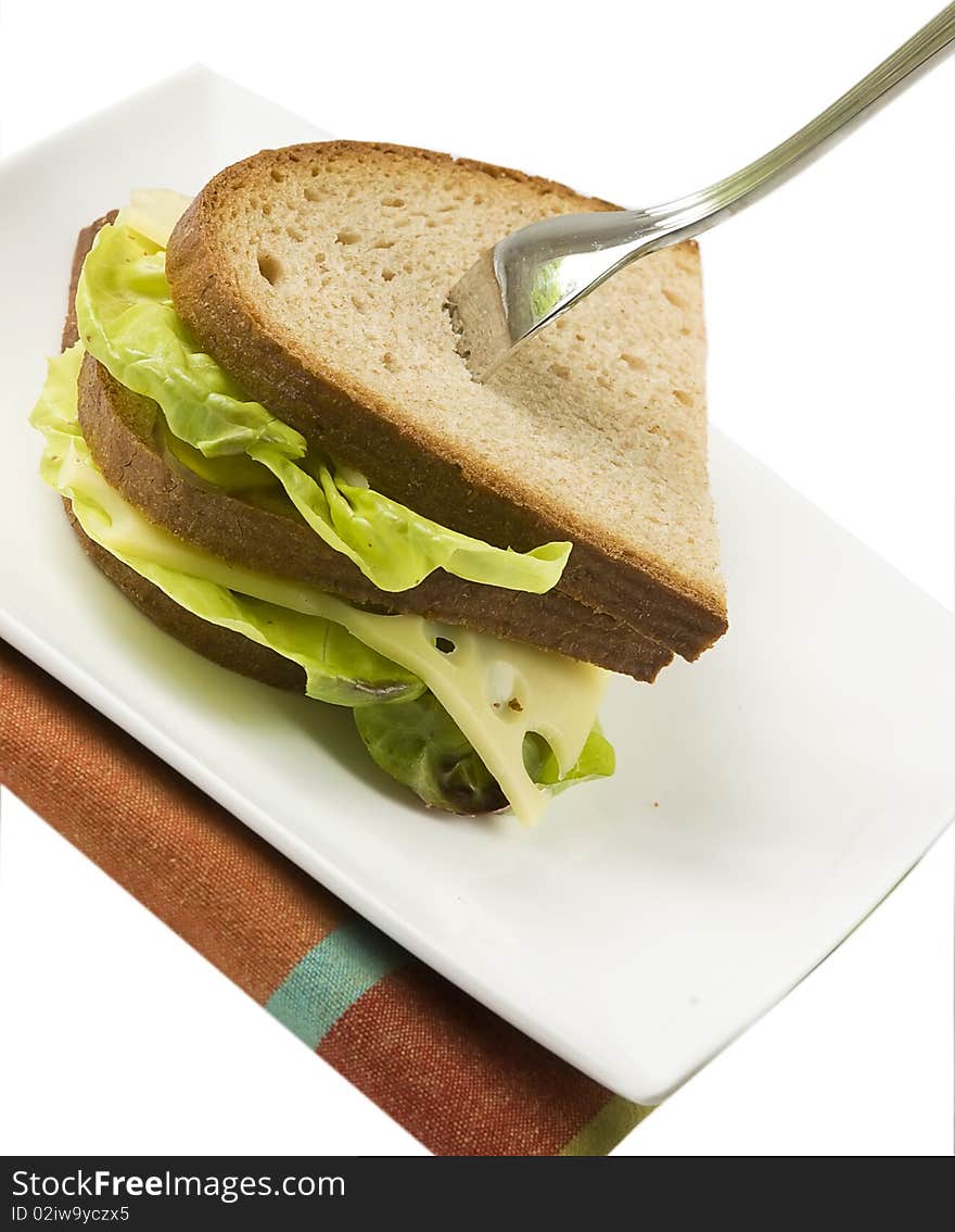 Dark bread sandwich with standing fork, isolated on white background