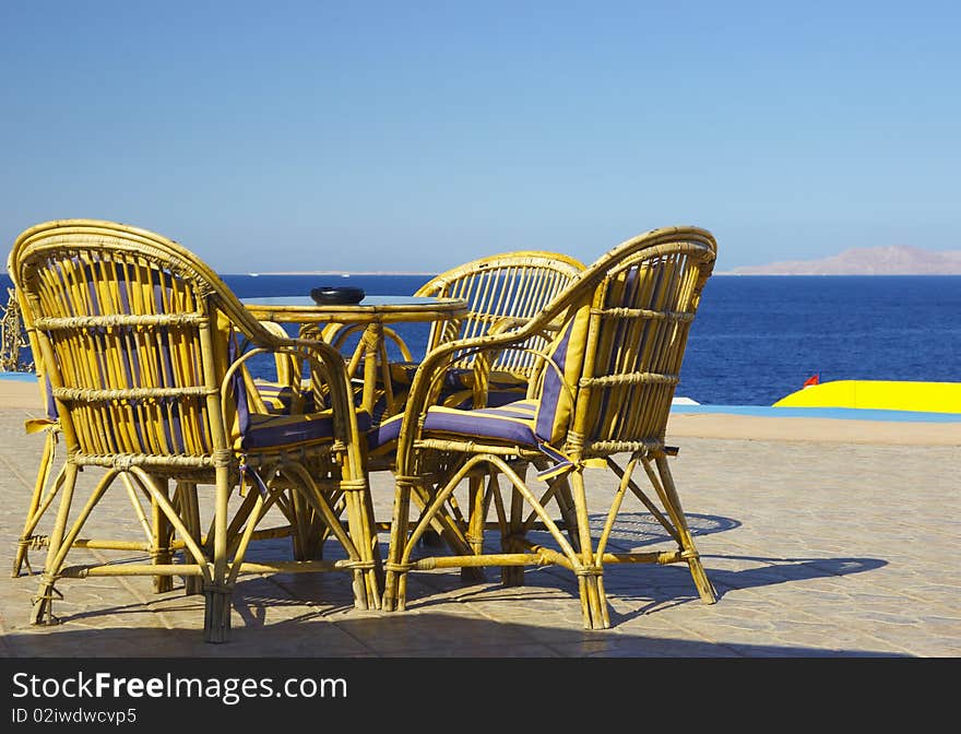 Table and chairs set at the coastline