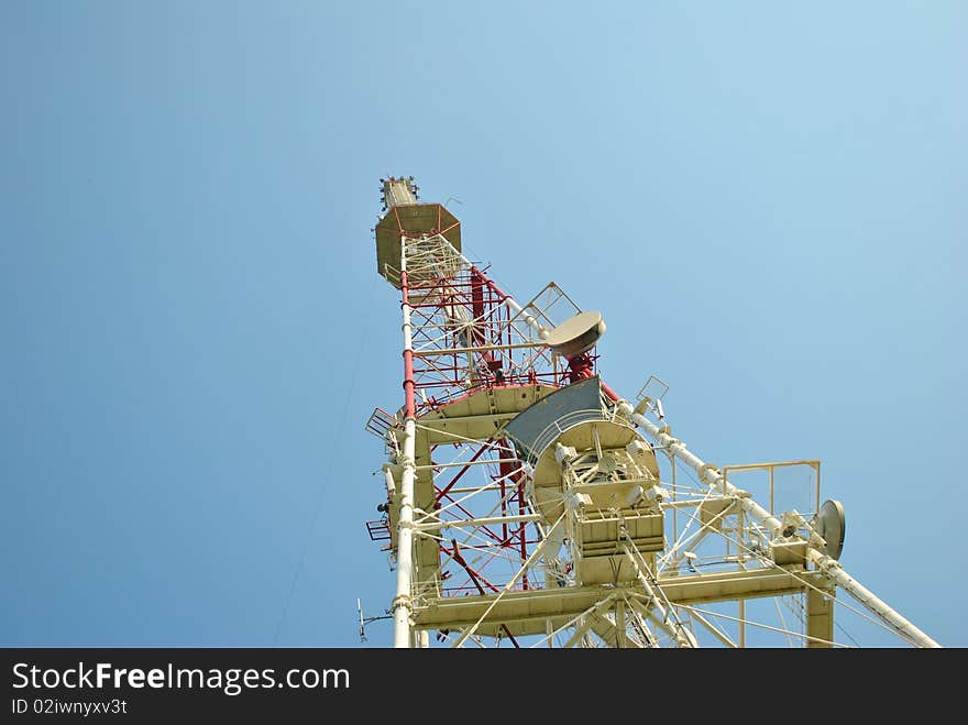 Communication tower over blue sky.