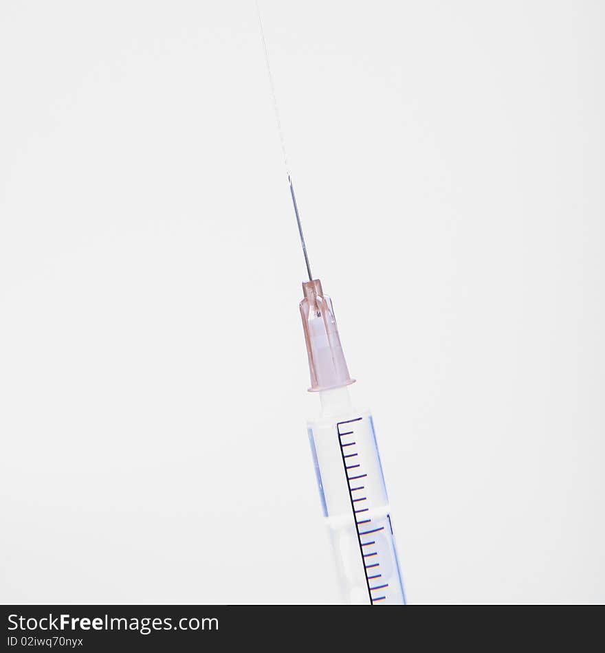 Syringe in close up with liquid coming out of it