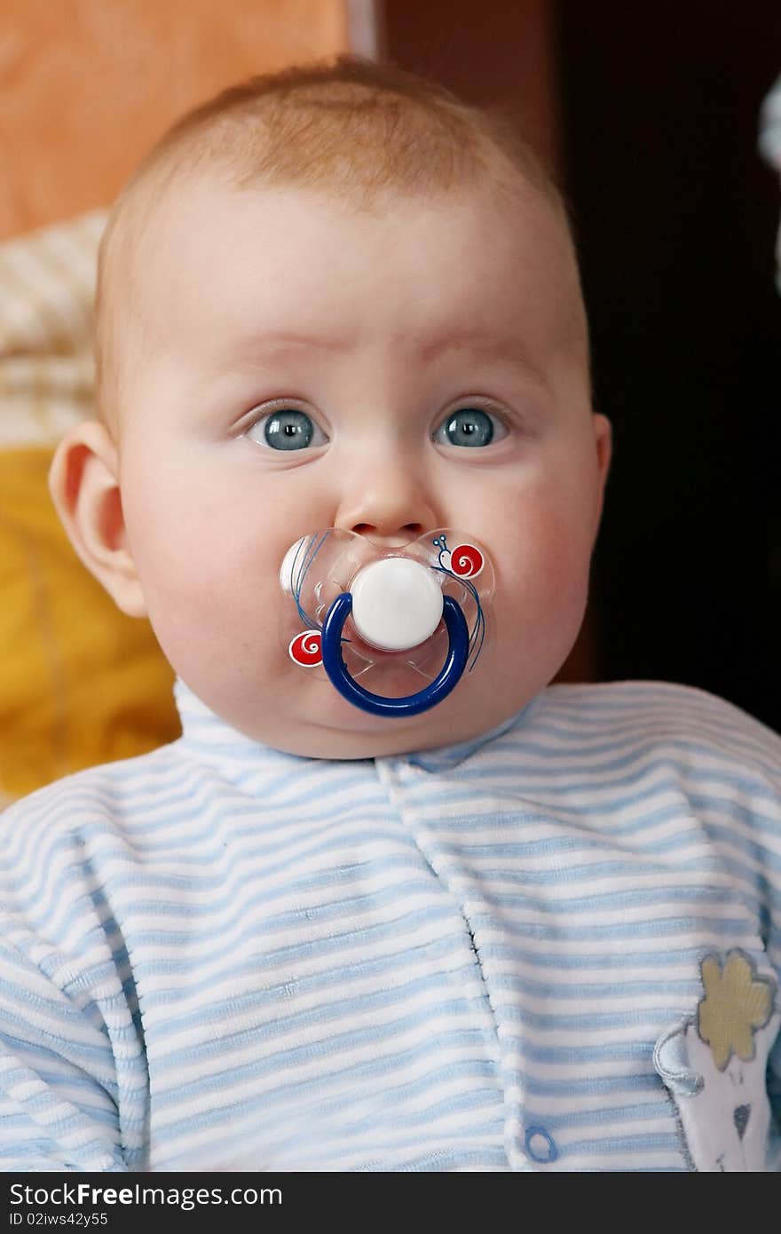 Portrait of little boy with baby's dummy in to the mouth