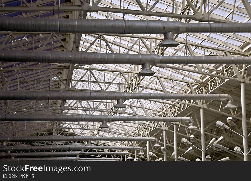 Frame of a metal truss. Roofs with top lighting. Part of the interior.