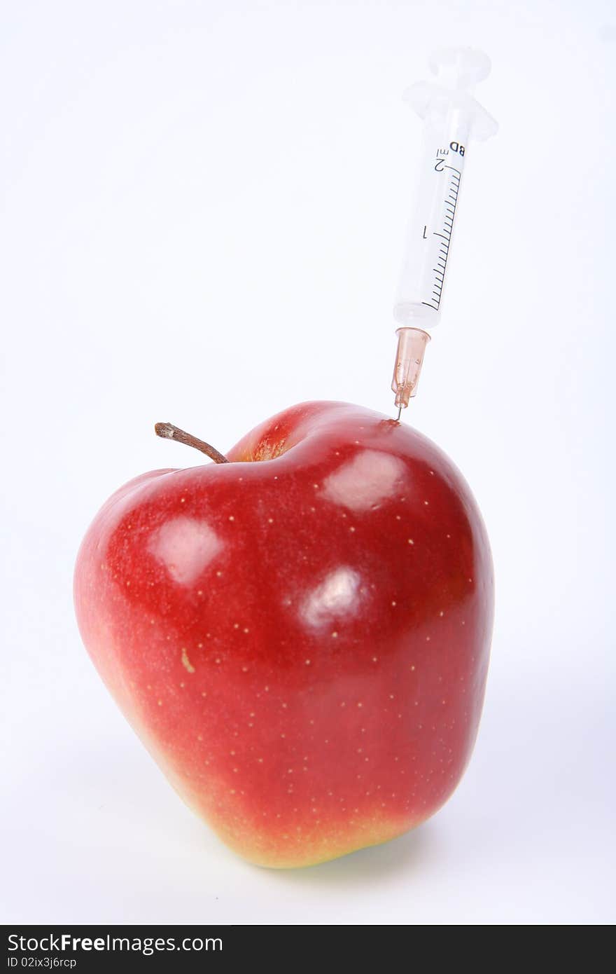 Apple with a syringe stick in it. Apple with a syringe stick in it