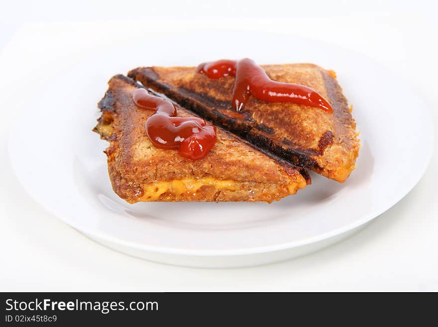 Toasted sandwich with cheese decorated with ketchup on a plate