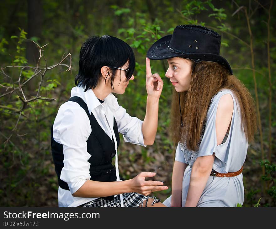 Two girls in the forest - fun stylization like cowgirl and Indian. Two girls in the forest - fun stylization like cowgirl and Indian