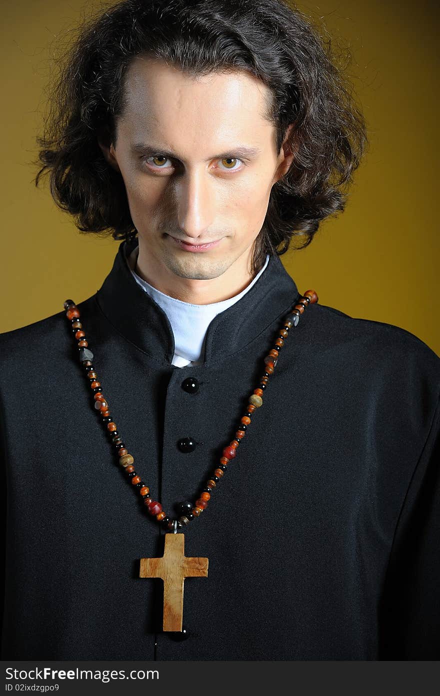 Praying priest with wooden cross