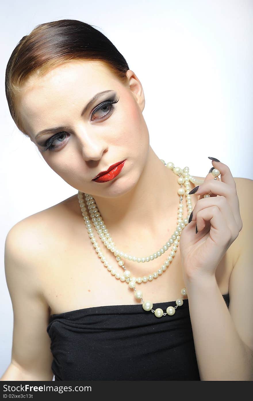 Young elegant aristocratic beauty female face with red shiny lips and black eye makeup. colse-up.