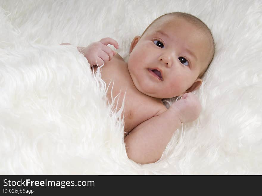 Sweet baby with funny face on white blanket. Sweet baby with funny face on white blanket