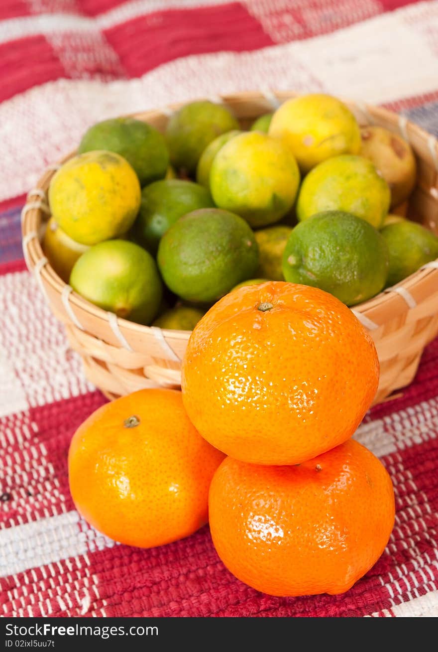 Basket of fruits alongside tangerines. Basket of fruits alongside tangerines