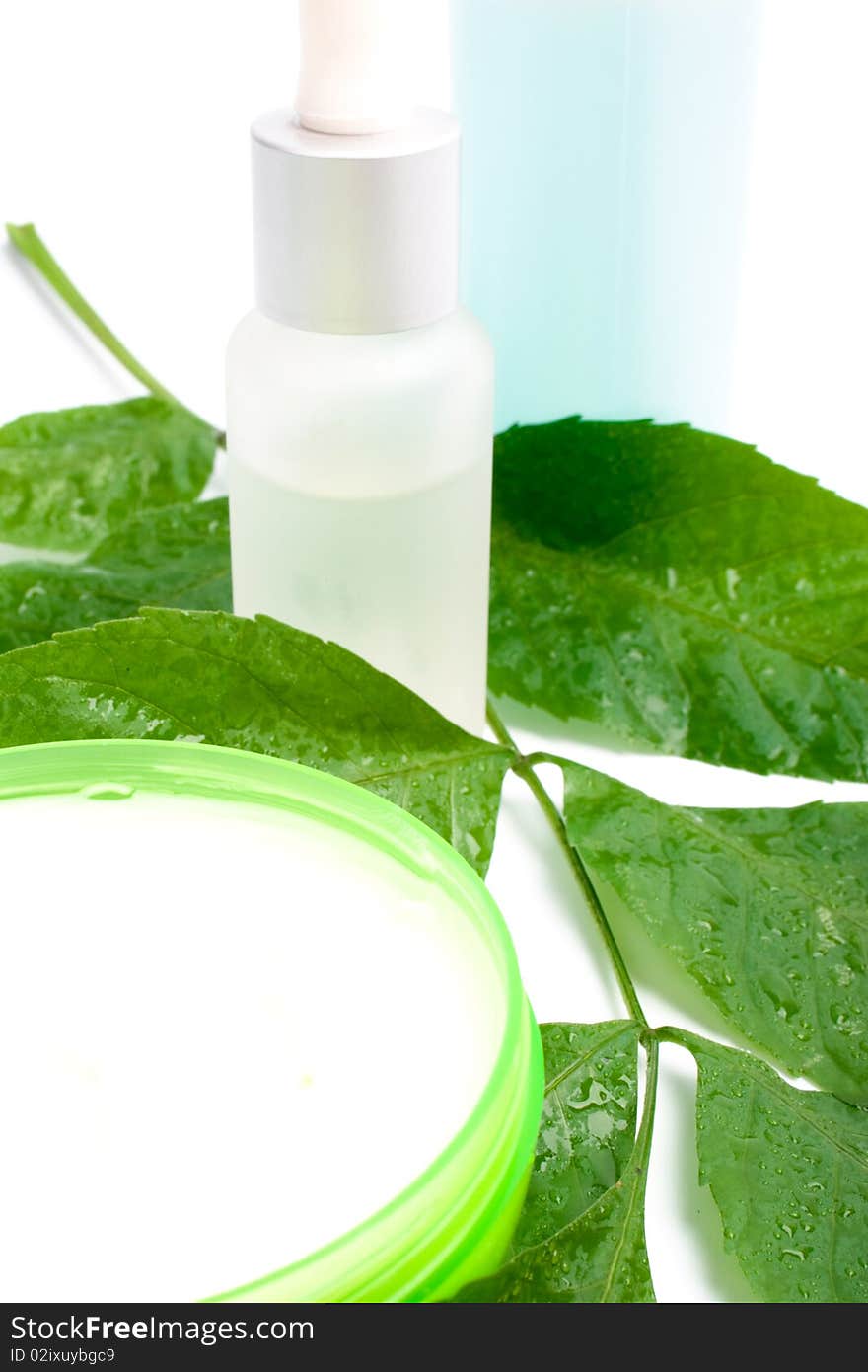 Cosmetic products with green leaf on white background