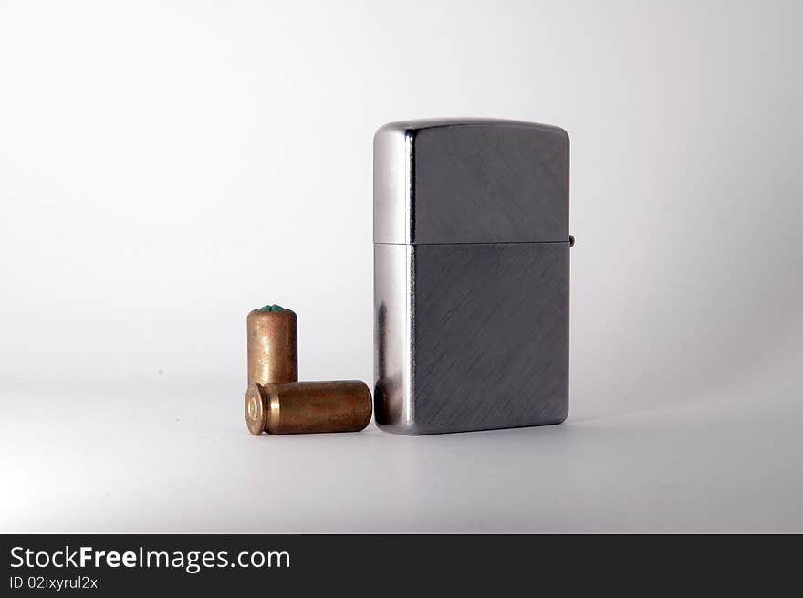 Metal Lighter and bullets on white background