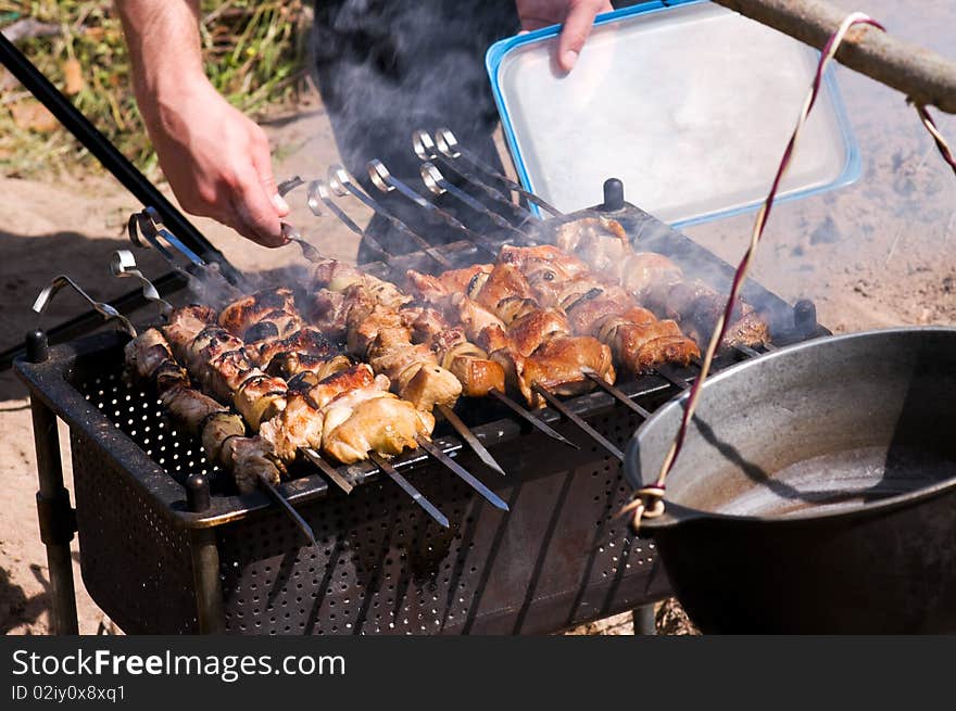 Big pieces of marinated pork and chicken on barbecue. Big pieces of marinated pork and chicken on barbecue