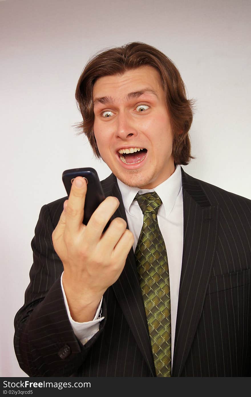 Angry businessman screaming on the mobile phone.