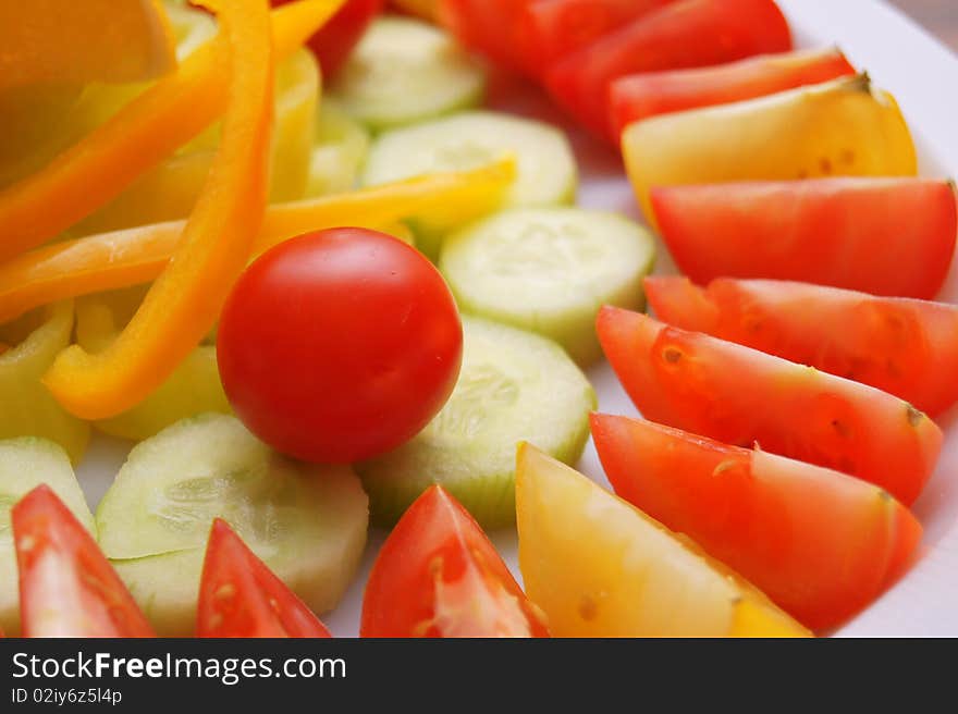 Vegetables tomato, cucumber, pepper on the white plate. Vegetables tomato, cucumber, pepper on the white plate