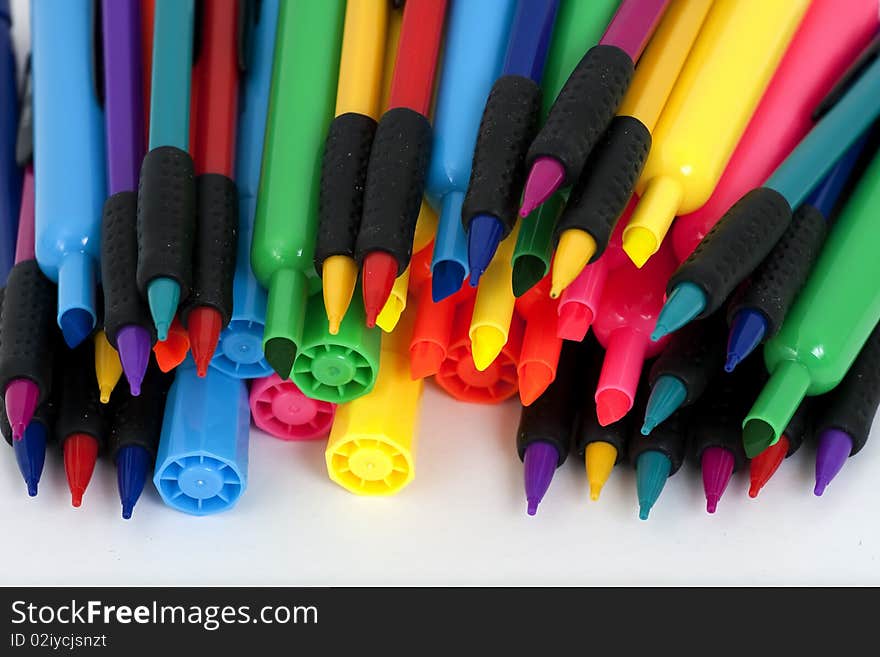 Colorful felt-tip markers and pencils on white background